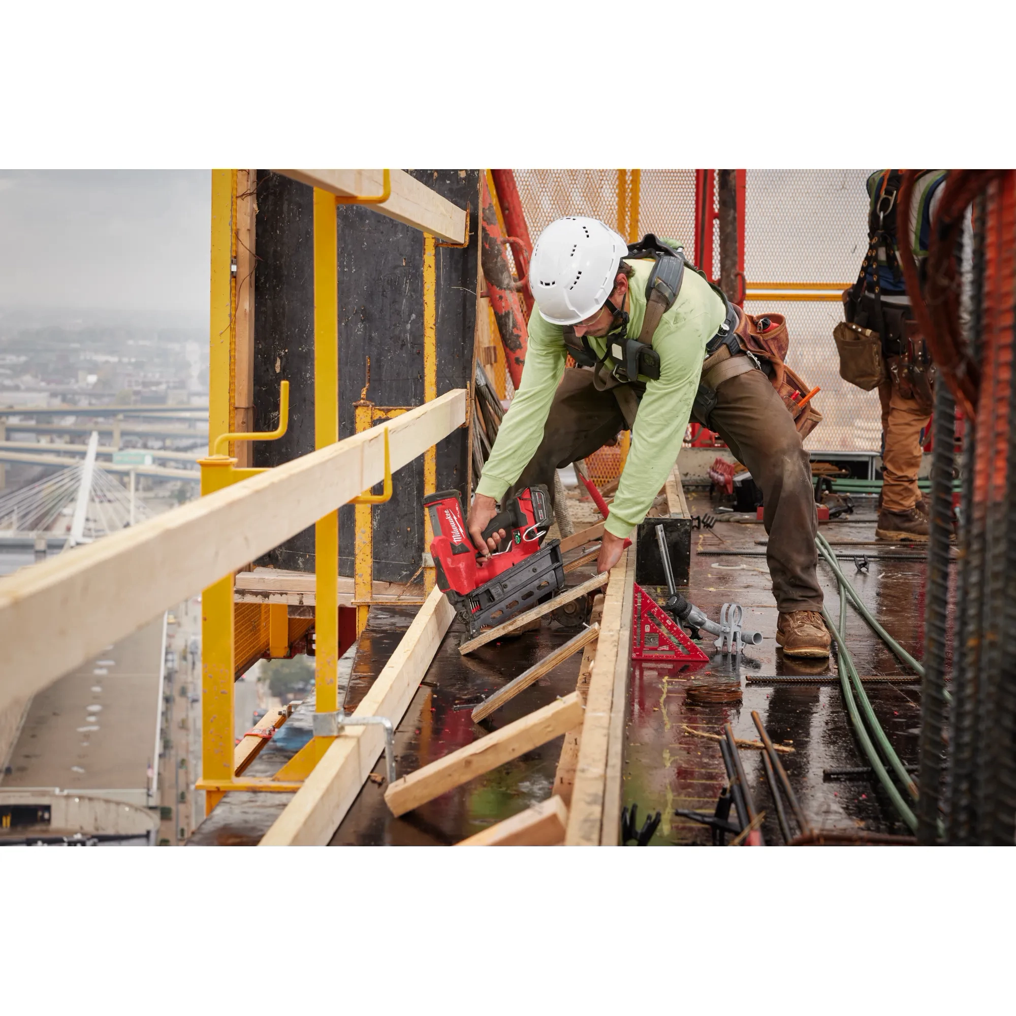 Image of  worker using the Milwaukee M18 Duplex Nailer to nail wood on a jobsite