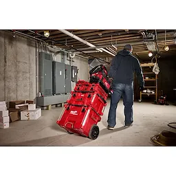 Image of the Milwaukee PACKOUT 15" Structured Tote and PACKOUT Rolling Toolbox being used by a worker on the jobsite