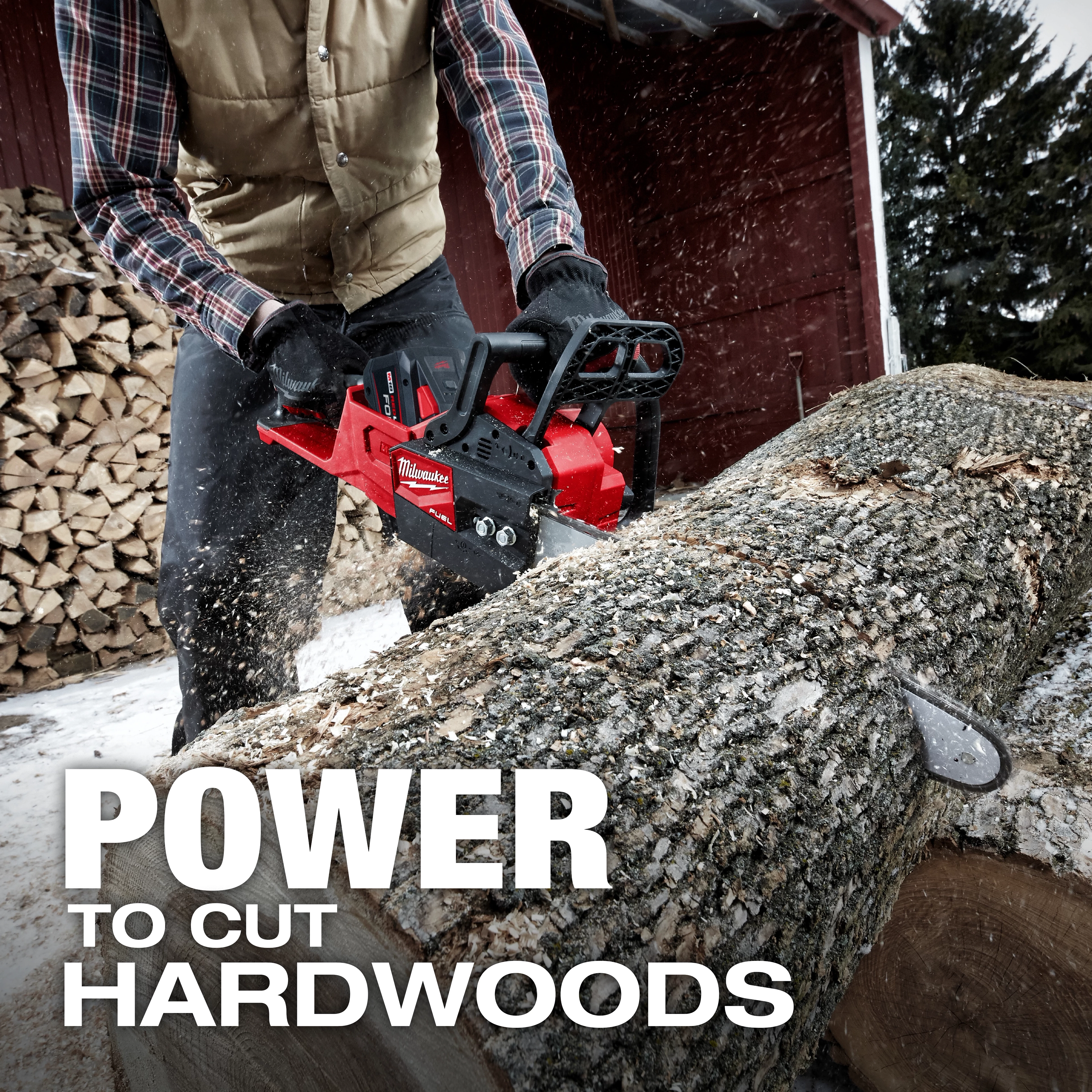 A person wearing gloves and a vest operates the M18 FUEL Chainsaw to cut a large log outdoors. Wood is stacked in the background. The text "POWER TO CUT HARDWOODS" is prominent in the foreground.