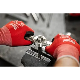 A person wearing red gloves is using the Hex-LOK™ 2-in-1 Threading Handle to thread a metal rod that is secured in a vise.